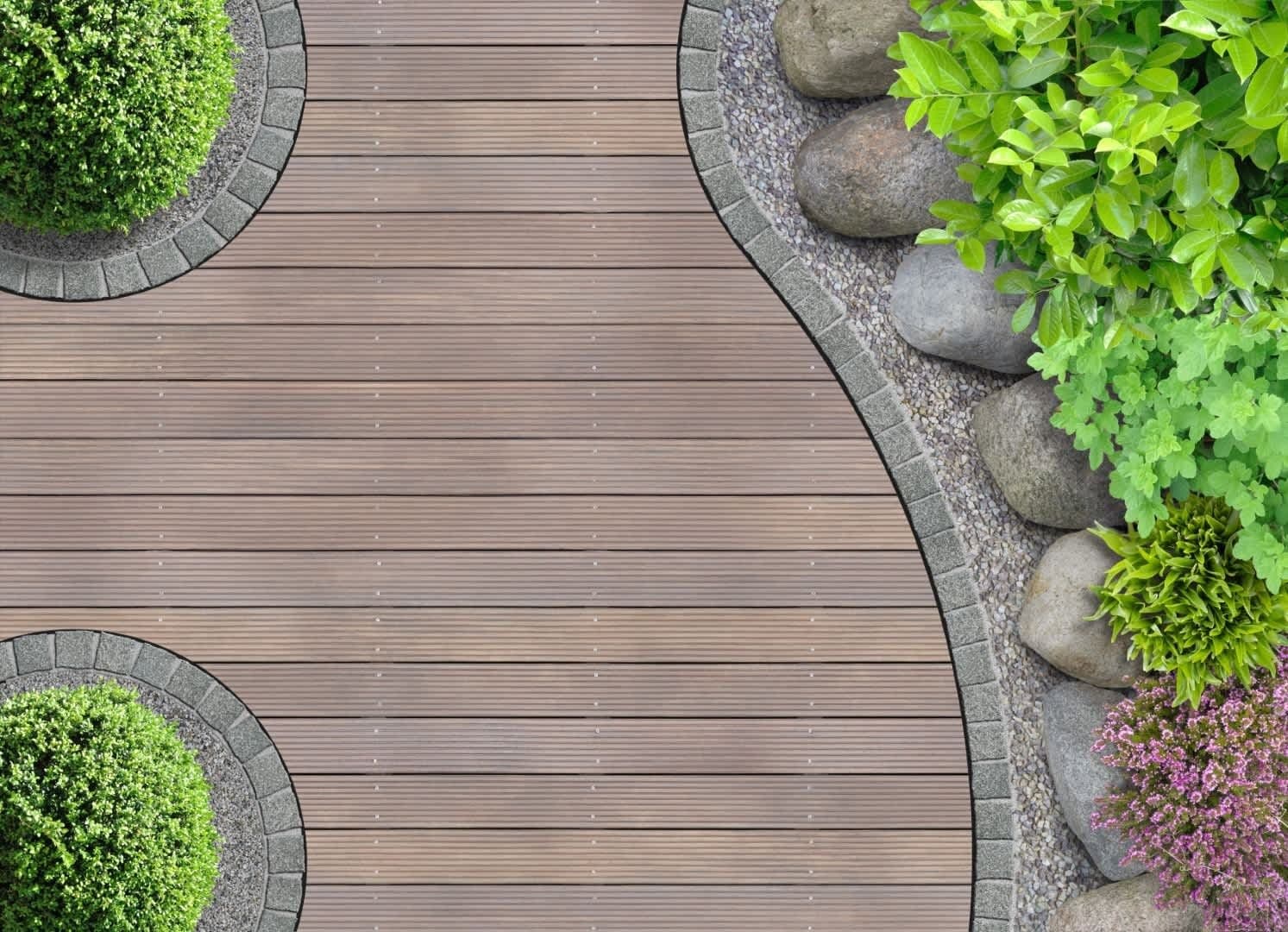 Houten vlonder met gebogen bestratingsrand, een kiezelstrook voor de afwatering en lage groenblijvende beplanting