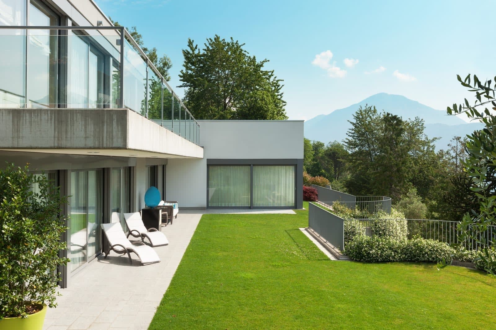 Moderne woning met een breed terras dat overloopt in een fris gemaaid gazon